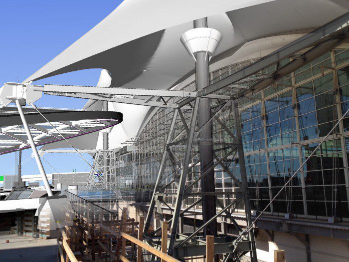 Maintaining the anchoring for the white tension fabric roof provided a challenge in the early planning and design stages. This photo/model composite shows the detail of the temporary grounding tower, serving as a window into the final support structure at this dramatic entry point to the main terminal. Courtesy HNTB.